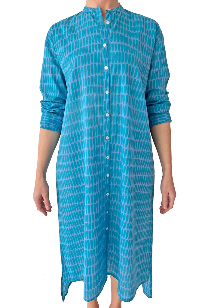 A stylish woman wearing a See Design blue shirt dress.